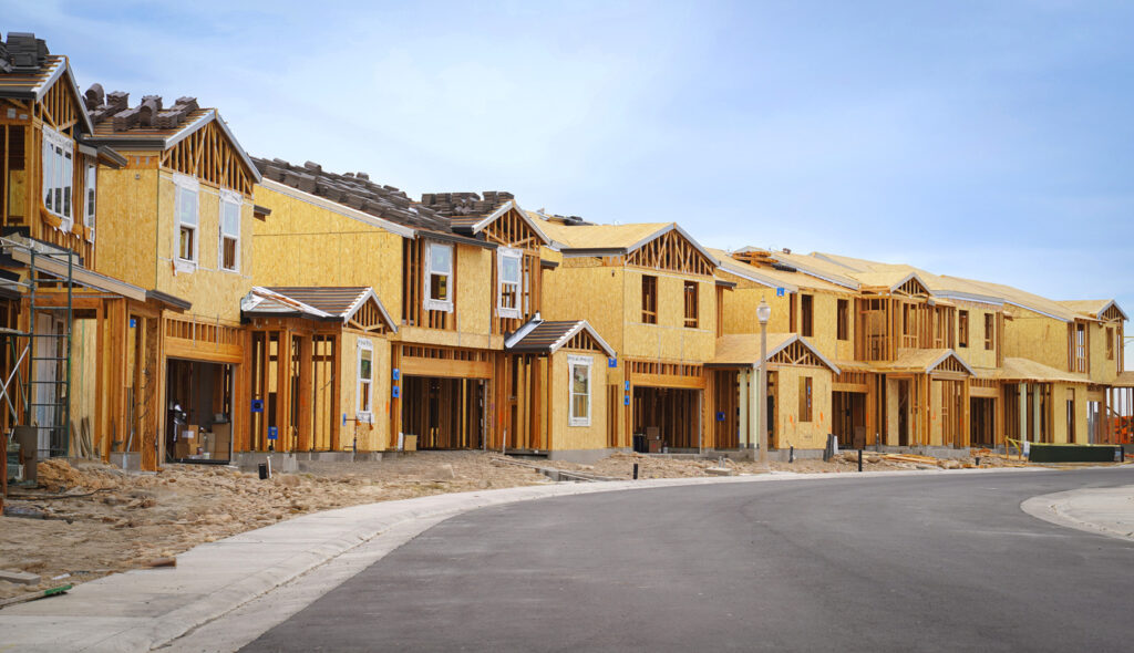 Single family homes  under construction on an empty street